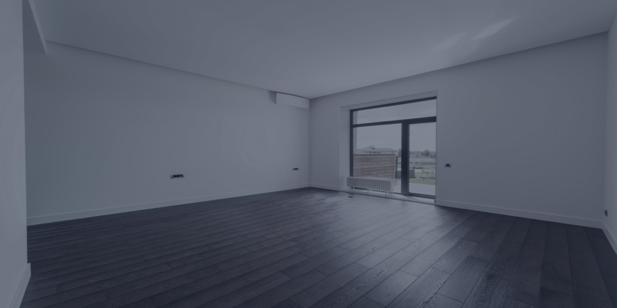 Sala vazia de apartamento novo, com piso de madeira e porta para a varanda